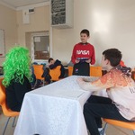 Trzech uczniów odgrywa scenę zamawiania posiłku w restauracji.