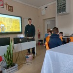 Dwóch uczniów odgrywa scenę zamawiania posiłku w restauracji.
