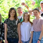 Grupa uśmiechniętych uczniów z pomalowanymi twarzami pozuje do zdjęcia.