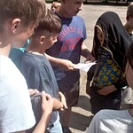 Kilku chłopców z klasy 6b czyta zadania zapisane na kartce tuż przed rozpoczęciem zabawy w podchody.