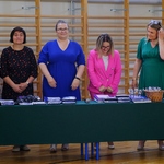 Pięć wychowawczyń klas ósmych stoi za stołem, na którym rozłożone są świadectwa i dyplomy.