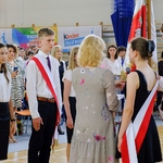 Uczniowie klas siódmych przejmują sztandar od starszych kolegów.