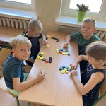 Uczniowie układają kompozycję z kolorowych zakrętek.jpg