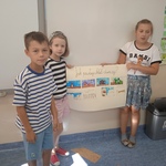 Grupa uczniów prezentuje plakat nt. Jak powstaje chleb dzisiaj.jpg