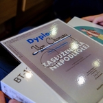 Laureat pokazuje dyplom i nagrodę.jpg