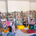 W bibliotece uczniowie klasy 5b siedzą na pufach i słuchają głośnego czytania książki..jpg