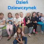 Uśmiechnięte uczennice pozują do zdjęcia. W tle napis - Dzień Dziewczynek..jpg