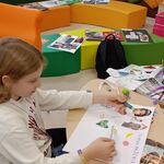 Uczennica siedzi przy stole i wykleja na kartonie papieru Mapę marzeń..jpg