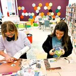 W bibliotece przy stole stoją dwie ucznnice i wyklejają z wycinków z gazet pracę Mapa marzeń..jpg