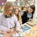 W bibliotece ucznnice stoją przy stole i wyklejają pracę Mapa marzeń..jpg