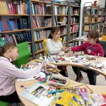 W bibliotece przy okrągłym stole siedzą trzy uczennice i tworzą pracę Mapa marzeń..jpg