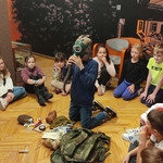 Chłopie zakłada maskę gazową i poznaje wyposażenie plecaka..jpg