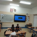 Uczniowie siedzący w klasie przy stolkach oglądająfilm o odnawialnych źródłach energii.jpg