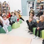 4 W bibliotece szkolnej na pufach siedzą uczniowie klasy 3 z swoją Panią wychowawczynią. W tle półki z książkami..jpg
