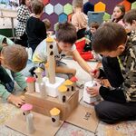 18 Uczniowie siedzą na dywanie i tworzą budowle z kartoników_ rolek po papierze..jpg