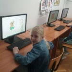 Uśmiechnięta dziewczynka siedzi przy komputerze_ prezentując wykonaną pracę w programie komputerowym.jpg