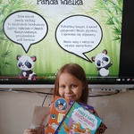 Dziewczynka z dyplomem i nagrodą pozuje na tle prezentacji o misiach.jpg