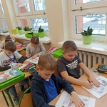 Dwóch chłopców siedzących przy stolikach uzupełnia andrzejkowe karty pracy.jpg