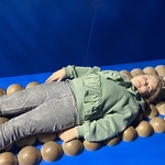 Dziewczynka leży na eksperymrntalnym łóżku składającym się z okrągłych wypustek.jpg