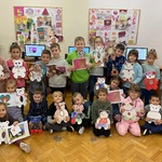Grupa dzieci prezentuje swoje prace plastyczne o misiach.