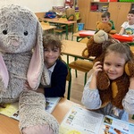 Czwórka uśmiechniętych dzieci pozuje do zdjęcia z ulubionymi pluszakami.