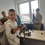 Chłopiec trzyma w ręku broń wojskową..jpg