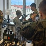 chłopak obserwuje i próbuje zasady posługiwania sie karabinem.jpg