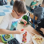Chłopiec przygotowuje owocowy szaszłyk.jpg