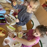 Grupa dzieci przygotowuje zdrowe posiłki przy stoliku.jpg