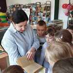 Pani biliotekarka prezentuje uczniom najstarszą książkę znajdującą się w  bibliotece szkolnej.jpg