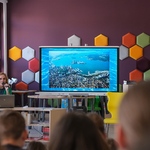 Zdjęcie 7 W bibliotece przy stoliku siedzi pisarka_ obok niej stoi duży ekran_ naprzeciw siedzą uczniowie..jpg