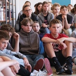 Zdjęcie 6 Uczniowie z kl. 6 siedzą na pufach i dywanie w bibliotece..jpg
