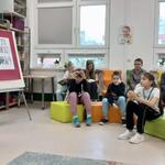 Zdjęcie 26 W bibliotece uczennica czyta wiersz_ Z boku siedzą uczniowie klasy 4c_.jpeg
