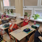 Uczniowie trzymają w górze zrobione przez siebie lizaki.jpg