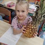 Uczennica trzyma w rękach ananasa.jpg