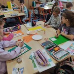 1. Dzieci siedzą przy stolikach w zespołach..jpg
