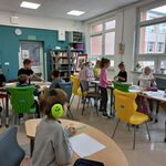 Zdjęcie 3 W bibliotece uczniowie siedzą przy stołach. Wykonują prace plastyczne..jpg