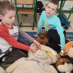 Chłopcy mierzący miarką dużego pluszowego misia..jpg