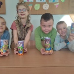 Czwórka dzieci z uśmiechem prezentująca kolorowe prace plastyczne w formie postaci misiów..jpg