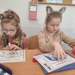 Dwie dziewczynki w klasie skupione na kolorowaniu misia_ na głowie mają opaski z uszami misia..jpg