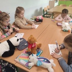 Dzieci w klasie skupione na rysowaniu przy stolikach_ obok nich leżą pluszowe zabawki..jpg
