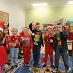 Grupa dzieci w świątecznych przebraniach prezentuje skarpety świąteczne..jpg