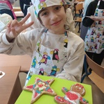 Dziewczynka z podniesioną ręką pokazuje ciastka.jpg