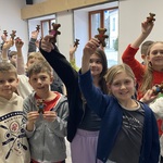 Grupa dzieci w wyciągniętych do góry rękach pokazuje własnoręcznie uszyte misie..jpg