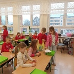 Dziewczynka i chłopiec częstują koleżanki słodyczami..jpg
