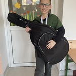 Chłopiec trzyma futerał na gitarę.jpg