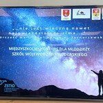 Na dużym ekranie telewizora jest wyświetlony plakat konkursu.jpg
