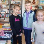 W bibliotece stoją uczniowie. W tle półki z książkami.jpg