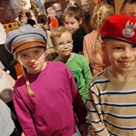 Dziewczynka z chłopcem przymierzają wojskowe nakrycia głowy.jpg
