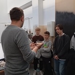 trzech chłopców z zaiteresowaniem słucha wykładu na temat pracy lasera.jpg